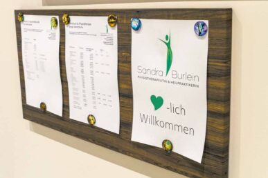 Schwarzes Brett der Praxis Burlein in Kornwestheim. Angehängt: Herzlich Willkommen und Preisliste für Patienten